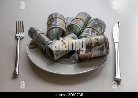 Cash in plate cent billets de dollars sur fond blanc, repas d'argent, concept de finance Banque D'Images