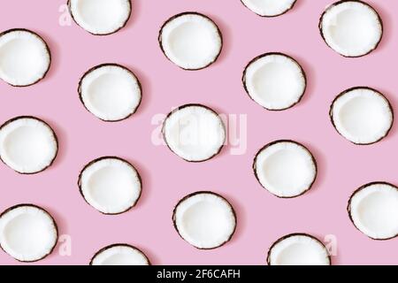 Motif noix de coco sur fond rose. Ensemble de moitiés de noix de coco. Photo de haute qualité Banque D'Images
