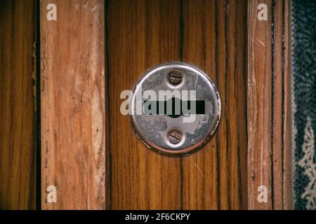 Ouverture horizontale en fer sur une ancienne porte en bois Banque D'Images