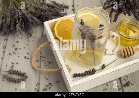 Thé de lavande avec miel et citron sur le bois blanc plateau Banque D'Images