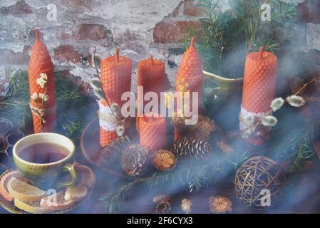 Le rideau estompe le premier plan. La vie encore brumeuse. Bougies décoratives en cire d'abeille avec un arôme de miel pour l'intérieur et la tradition. Banque D'Images