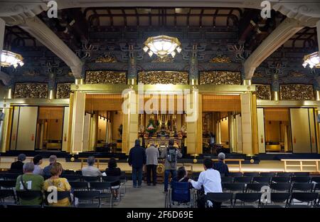 Tokyo, Japon - 23 octobre 2019 : la vue de la salle principale du temple bouddhiste Tsukiji Hongan-ji avec des gens qui prient devant l'autel avec la statue Banque D'Images