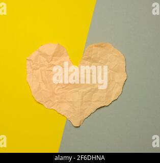 coeur en papier déchiré sur fond gris-jaune, vue de dessus Banque D'Images
