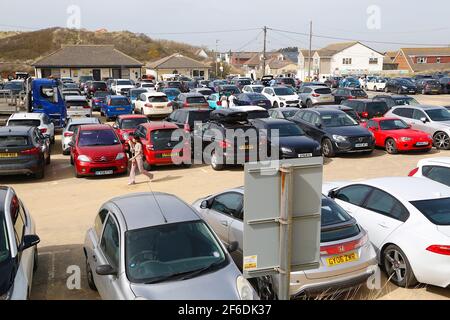 Camber, East Sussex, Royaume-Uni. 31 mars 2021. Météo au Royaume-Uni : le temps chaud se poursuit ici à Camber Sands, dans l'est du Sussex. Les familles arrivent tôt pour choisir une place sur la plage de sable doré. Parking en bord de plage. Crédit photo : Paul Lawrenson/Alay Live News Banque D'Images