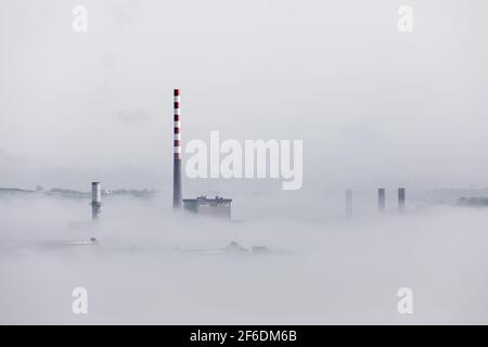 Aghada, Cork, Irlande. 31 mars, 2021.le soleil du matin commence à se démailler le brouillard marin qui enveloppe les réservoirs de stockage de la raffinerie de pétrole et de la centrale électrique à Aghada, Co. Cork, Irlande. - crédit; David Creedon / Alamy Live News Banque D'Images