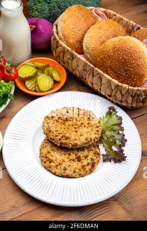 Préparation de hamburgers végétariens avec des patties rondes ou hamburgers à base de céréales, légumes et légumineuses Banque D'Images