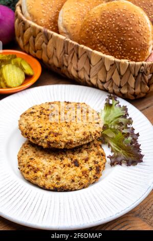 Préparation de hamburgers végétariens avec des patties rondes ou hamburgers à base de céréales, légumes et légumineuses Banque D'Images