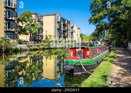 Un bateau à rames coloré s'amarre sur le canal Regents près de Mile End et de Victoria Park, Londres, Royaume-Uni Banque D'Images