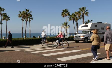 Oceanside, Californie Etats-Unis - 8 février 2020: Motorhome, les gens qui font du vélo sur ped traversant Zebra, Waterfront Road. Océan Pacifique tropical plage touristique re Banque D'Images