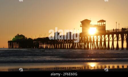 Oceanside, Californie États-Unis - 16 février 2020 : silhouette de surfeur, plage de l'océan pacifique en soirée, vagues d'eau et coucher de soleil. Littoral tropical, secteur riverain Banque D'Images