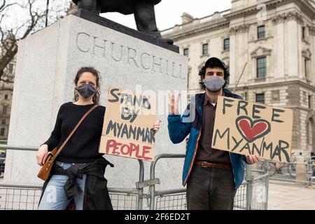 Londres, Royaume-Uni. 31 mars 2021. Des manifestants tenant des pancartes près de la statue de Winston Churchill sur la place du Parlement. Les manifestants se sont rassemblés sur la place du Parlement - portant un masque facial et observant les distances sociales - avant de marcher vers l'ambassade chinoise en solidarité avec le peuple du Myanmar contre le coup d'État militaire et les meurtres de civils par l'État. Des discours ont été prononcés à l'extérieur de l'ambassade. Depuis le début du coup d'État militaire le 1er février, plus de 520 personnes ont été tuées au Myanmar par les forces de sécurité. Samedi dernier a été le jour le plus violent où plus de 100 personnes ont été tuées. CRED Banque D'Images