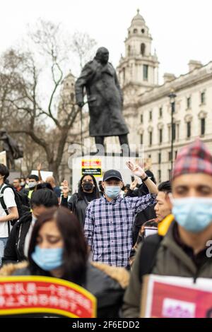 Londres, Royaume-Uni. 31 mars 2021. Manifestants à côté de la statue de Winston Churchill sur la place du Parlement. Les manifestants se sont rassemblés sur la place du Parlement - portant un masque facial et observant les distances sociales - avant de marcher vers l'ambassade chinoise en solidarité avec le peuple du Myanmar contre le coup d'État militaire et les meurtres de civils par l'État. Des discours ont été prononcés à l'extérieur de l'ambassade. Depuis le début du coup d'État militaire le 1er février, plus de 520 personnes ont été tuées au Myanmar par les forces de sécurité. Samedi dernier a été le jour le plus violent où plus de 100 personnes ont été tuées. Crédit: Joshua Windso Banque D'Images