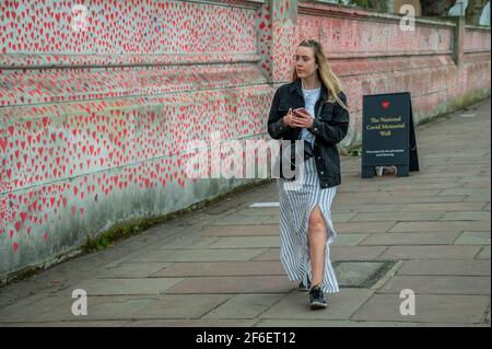 Londres, Royaume-Uni. 31 mars 2021. Le mur national du Covid Memorial à l'extérieur de l'hôpital St Thomas, sur la rive sud. La famille et les amis de quelques-uns des plus de cent quarante-cinq mille personnes qui ont perdu la vie à Covid-19 attirent le cœur à la main sur un mur en face du Parlement de Londres. Chaque cœur représente quelqu'un qui était aimé. Quelqu'un qui a été perdu trop tôt à Covid-19. Ils organisent ce mémorial temporaire car "ils ne croient pas que c'est à ceux qui ont dirigé la réponse de ce pays à Covid-19 de décider comment nous nous en moquons". Une fois installés, ils gardera le mémorial Banque D'Images