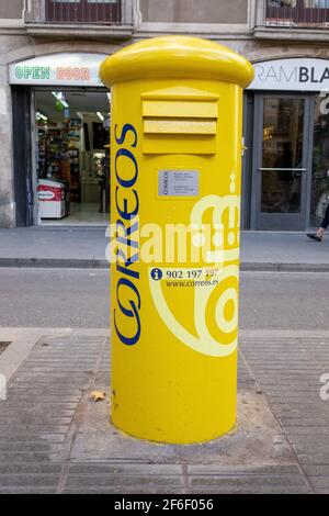 Service postal espagnol jaune (Correos) boîte postale boîte à lettres Pillarbox on Une rue de Barcelone Espagne Banque D'Images