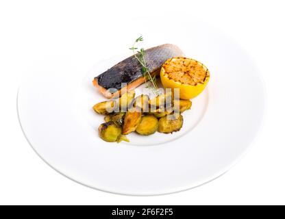 Filet de saumon grillé avec des pousses de saumure et des tranches de citron. Isolé sur un fond blanc. Banque D'Images