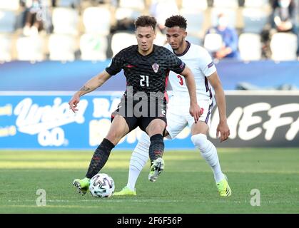 Dario Spikic (à gauche) en Croatie et Lloyd Kelly en Angleterre se battent pour le ballon lors du championnat européen des moins de 21 ans de l'UEFA 21 au stade Bonifacika de Koper, en Slovénie. Date de la photo: Mercredi 31 mars 2021. Banque D'Images