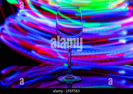 verre à vin sur fond de rayures colorées Banque D'Images