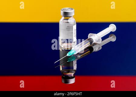 Concept de vaccin avec drapeau de la Colombie réfléchi et défoqué, accent sélectif sur le vaccin Banque D'Images