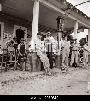 Le 4 juillet, près de Chapel Hill, en Caroline du Nord. Les stations de remplissage rurales deviennent des centres communautaires et des terrains de loafing généraux. Les hommes des combinaisons de baseball font partie d'une équipe locale qui jouera un match à proximité. Ils sont appelés l'équipe de Cedargrove. 1939. Photo de Dorothea Lange. Banque D'Images