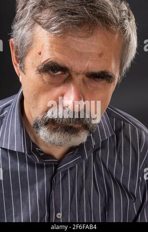 Homme âgé aux cheveux gris en colère, qui a l'air sulfuré Banque D'Images