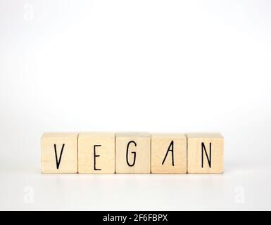 Vegan et hashtag écrit avec des cubes en bois et la décoration de la nature isolée sur fond blanc avec espace de copie, vegan, végétarien, concept de santé Banque D'Images