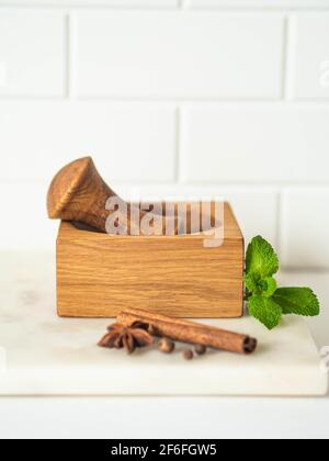 Cuisson des herbes et des épices sur une table en marbre. Mortier de bois et pâtes et diverses épices et herbes. Vue avant. Copier l'espace Banque D'Images