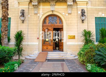 Le Caire - Égypte - 4 octobre 2020 : porte en bois antique décorée dans un mur en briques de pierre. Entrée du musée de la Présidence. Façade du Palais Royal d'Abdeen. Banque D'Images