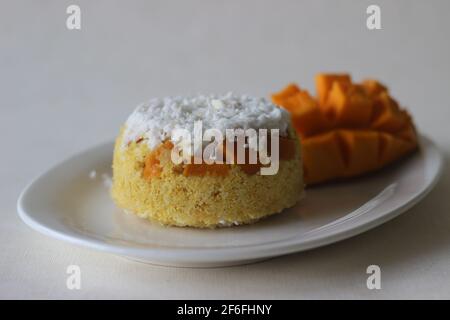 Riz moulu à la vapeur, en couches de copeaux de noix de coco et de mangue. Connu localement sous le nom de Mango Puttu. Un plat de petit déjeuner sain traditionnel de Kerala. Prise de vue sur wh Banque D'Images