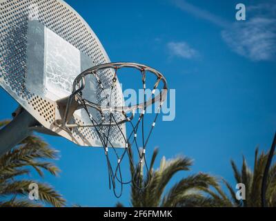 Un cliché en contre-angle d'un panier de basket-ball contre un ciel bleu ensoleillé Banque D'Images