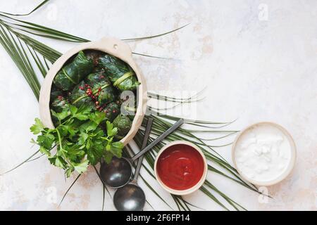 Rouleaux de printemps de bettes avec sauces au poivre rouge et au yaourt, servis dans un plat traditionnel de crock, prêts à manger. Vue de dessus, espace vierge Banque D'Images