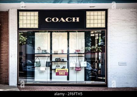 2020 07 14 Tulsa USA - Afficher la fenêtre de la boutique Coach avec l'été Panneau de vente et réflexions de voitures et d'arbres Banque D'Images