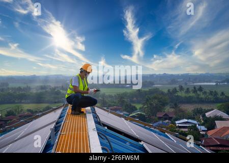 cellules solaires, technicien utiliser une tablette travaillant à la centrale solaire sur le toit, l'énergie solaire, Banque D'Images