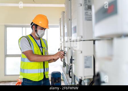 technicien vérifiant l'énergie solaire du contrôleur des panneaux solaires Banque D'Images