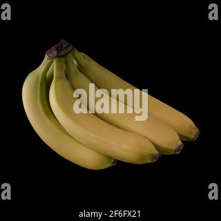 Un bouquet de plusieurs bananes mûres sur fond noir, isolées Banque D'Images
