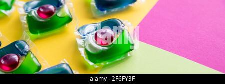 capsules pour le lavage avec du gel vert et jaune sur un espace de copie en arrière-plan blanc Banque D'Images