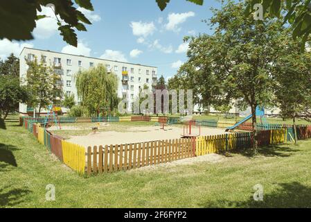 Bloc vert d'appartements dans le domaine du logement avec aire de jeux pour les enfants et les arbres. Paysage urbain avec appartements Banque D'Images