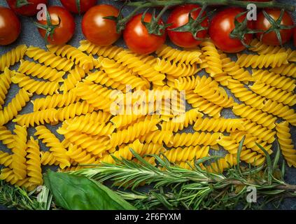 Pâtes fusilli crues aux tomates, aux herbes et au basilic. Pâtes italiennes aux ingrédients aux couleurs du drapeau italien. Photo de haute qualité Banque D'Images