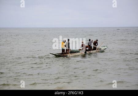 salvador, bahia, brésil - 18 décembre 2020: Les pêcheurs sont vus pousser un canoë dans la mer à côté de la colonie de pêcheurs sur la plage de Pituba, dans la ville o Banque D'Images