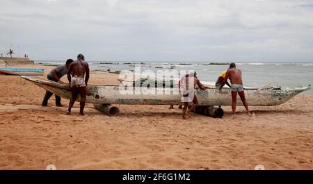 salvador, bahia, brésil - 18 décembre 2020: Les pêcheurs sont vus pousser un canoë dans la mer à côté de la colonie de pêcheurs sur la plage de Pituba, dans la ville o Banque D'Images