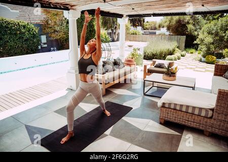 Mixte course flexible adolescent étirant dos faire de l'exercice yoga à l'extérieur de la maison Banque D'Images