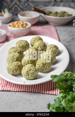 Boulettes de falafel traditionnelles maison de pois chiches avec sauce blanche et pain pita sur plaque blanche sur planche de bois, concept sain de vie végétarienne Banque D'Images