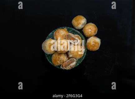 Une pâtisserie asiatique traditionnelle ou Tao SOR sur fond noir. Pâtisserie sucrée chinoise remplie de pâte de haricots mung, de taro et d'œuf salé, l'un des célèbres snac Banque D'Images