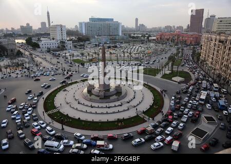 31 mars 2021, Egypte, le Caire: Une vue générale de la place El-Tahrir avec des véhicules traversant le rond-point principal orné de l'Obélisque des statues de Ramses II et Rams. Selon le ministère égyptien du Tourisme et des Antiquités, 22 momies seront transférées du Musée égyptien de Tahrir au Musée national de la civilisation égyptienne de Fustat. Les momies qui seront transférées comprennent Pharaon Ramses II; Pharaon Ramses IX; Pharaon Ramses VI; Pharaon Ramses V; Pharaon Seti I; Pharaon Seqenenre; et Pharaon Thutmose III, ainsi que la reine Hatshepsout; la reine Meritamun, la femme de Banque D'Images