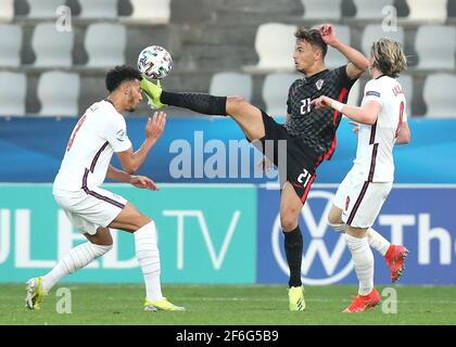 Dario Spikic (au centre) en Croatie et Lloyd Kelly en Angleterre se battent pour le ballon lors du championnat européen des moins de 21 ans de l'UEFA 21 au stade Bonifacika de Koper, en Slovénie. Date de la photo: Mercredi 31 mars 2021. Banque D'Images