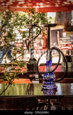 Pipe à eau ou nargua ou shisha pour fumer du tabac sur la table De café-terrasse dans Bohemian Tbilissi Géorgie - foyer sélectif avec des réflctions Banque D'Images