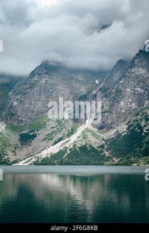 Tempête nuageux au-dessus du lac Morskie Oko reflétée dans l'eau. Montagnes Tatra, Pologne Banque D'Images
