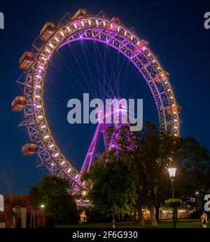 La roue du Prater Ferris : Riesenrad Wurstelprater après la tombée de la nuit : le célèbre parc de loisirs de Vienne, l'attraction la plus célèbre d'une immense roue antique de ferris juste après le coucher du soleil, éclairée par ses nombreuses lumières contre un ciel sombre. Banque D'Images