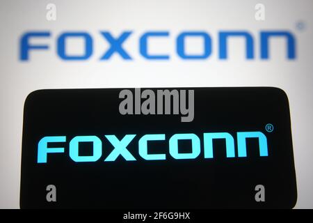 Dans cette illustration, le logo Foxconn d'un fabricant de contrats électroniques multinationaux taïwanais vu sur un smartphone et un écran de pc. Banque D'Images