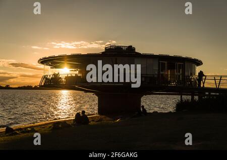 Porto Alegre, Rio Grande do Sul, Brésil, du 29 au 2021 mars : restaurant panoramique sur le front de mer de Guaíba en silhouette au coucher du soleil. Banque D'Images