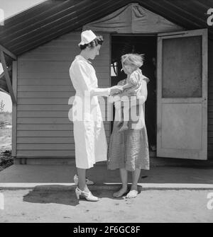 Camp de l'Administration de la sécurité agricole (FSA). Farmersville, Tulare County, Californie. Montre que l'infirmière résidente vient rendre visite à la famille où il y a un bébé malade. 1939. Photo de Dorothea Lange. Banque D'Images